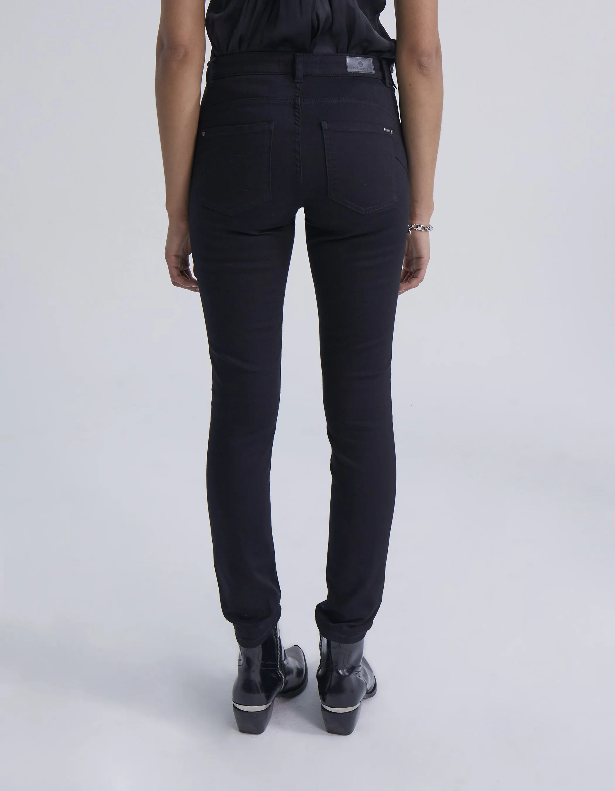 Black slim fit jeans with sculpting effects and side studs for women